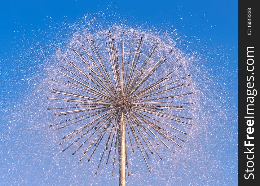 Fountain as dandelion with a blue sky
