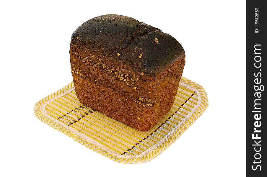 Loaf of rye bread with caraway on a yellow bamboo mat