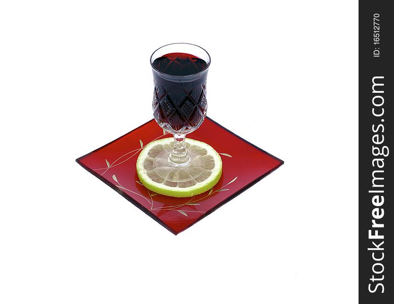 A wineglass of  red wine with one slice of lemon