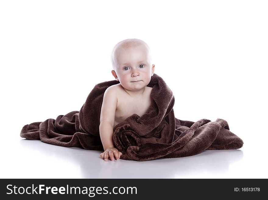 Beautiful baby under a brown towel on white background