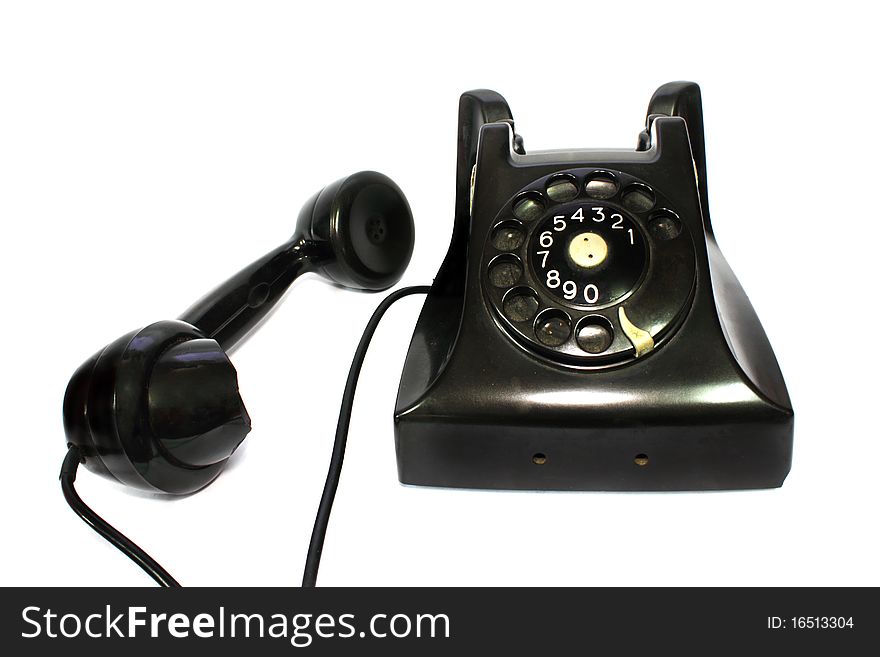 Old-fashioned black telephone receiver with cord on white background