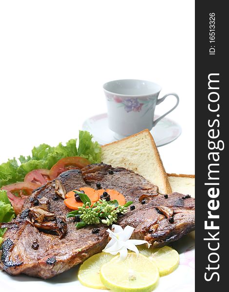Closeup of T Bone Pepper Steak dressing by vegetable and bread with Coffee cup