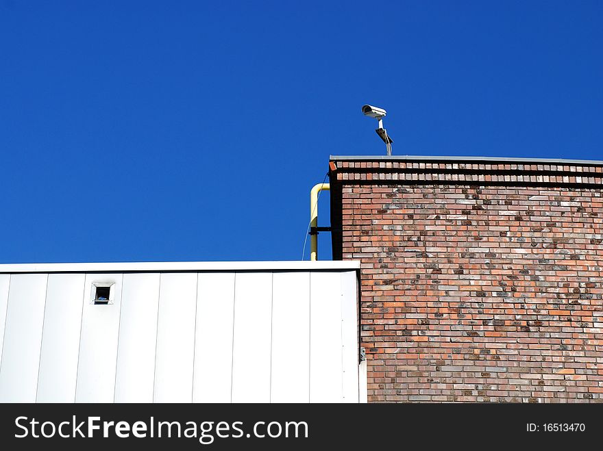 Security camera mounted on the facade of the modern building. Security camera mounted on the facade of the modern building.