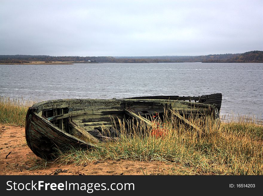 Boat sunk in sand at shore of river Varzuga At Kolsky peninsula. Boat sunk in sand at shore of river Varzuga At Kolsky peninsula