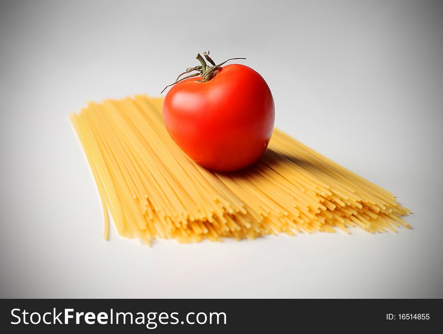 Tomatoe on a handful of spaghetti. Tomatoe on a handful of spaghetti