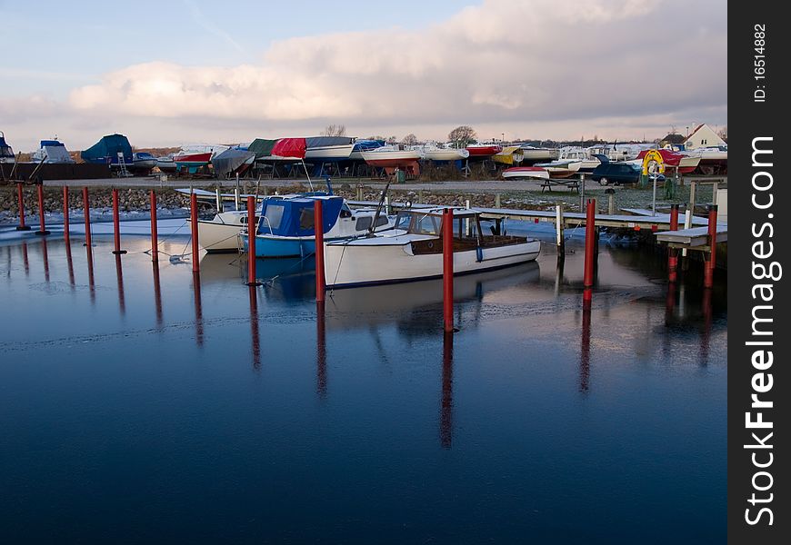 Yachts and sail boats moored to docks in a marina / sailing background image. Yachts and sail boats moored to docks in a marina / sailing background image