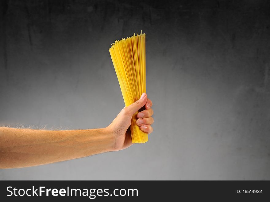 Man's hand holding a handful of spaghetti