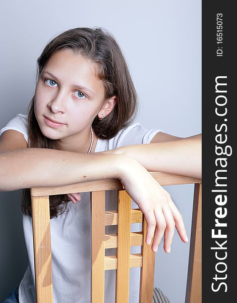 Portrait of a teenage girl sitting on a chair. Portrait of a teenage girl sitting on a chair