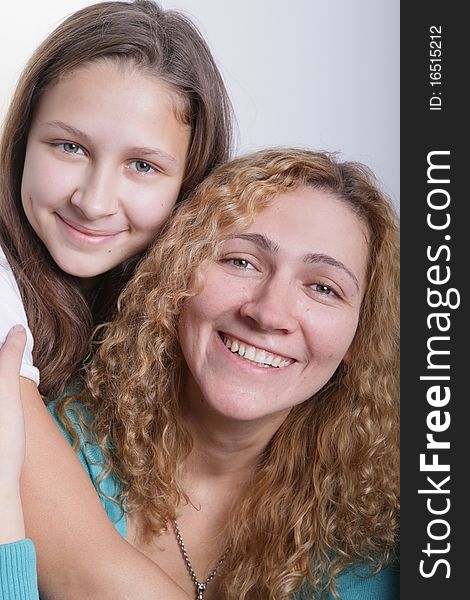 A portrait of mother and duaghter on a light background. A portrait of mother and duaghter on a light background