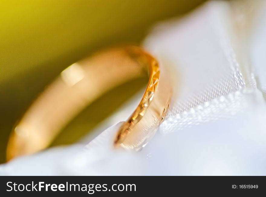 Classic gold wedding ring on white satiny fabric. Classic gold wedding ring on white satiny fabric