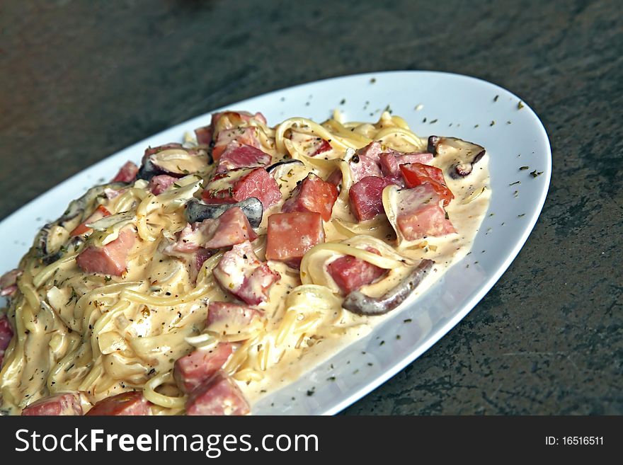 Perspective of spaghetti carbonara with ham