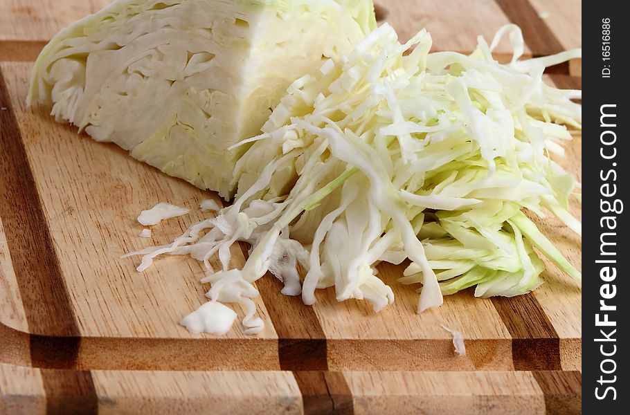 Green cabbage on wooden cutting board