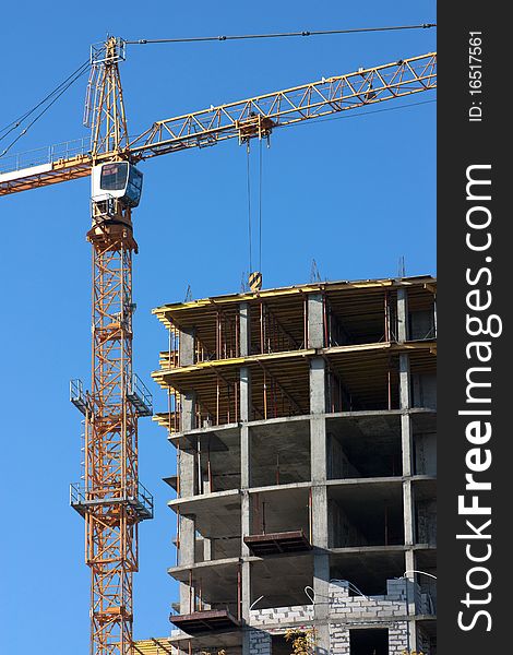 Big crane tower constructs modern building. Big crane tower constructs modern building