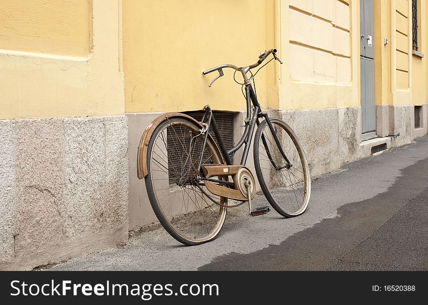 An old broken bicycle in the street. An old broken bicycle in the street