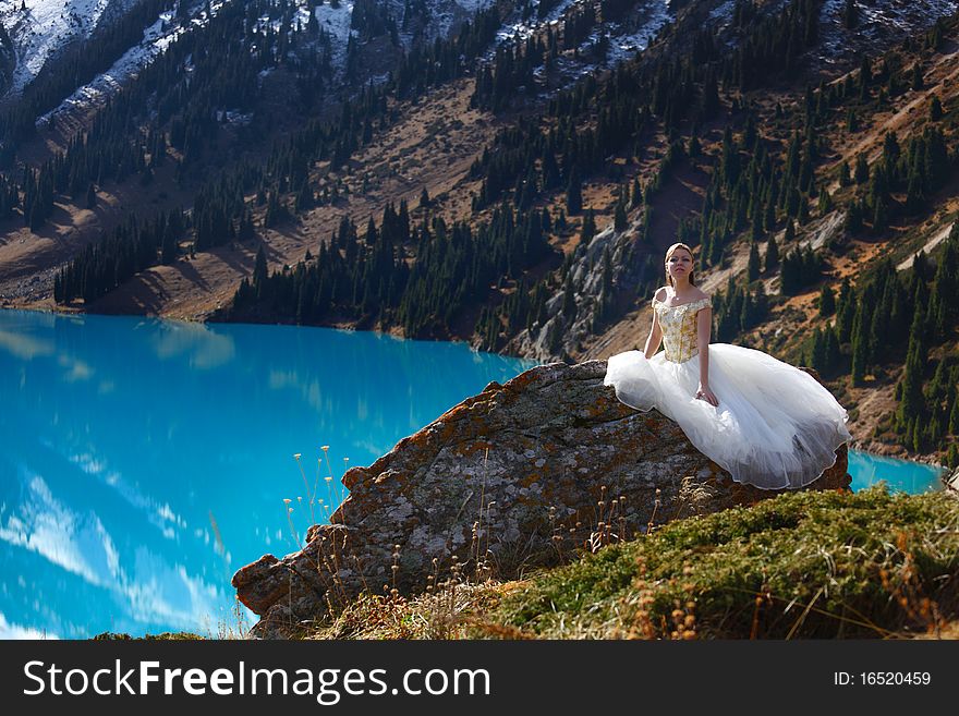 The girl in a wedding dress at mountain lake