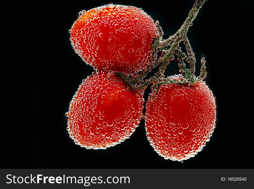 Three beautiful fresh tomato in water, In bubbles