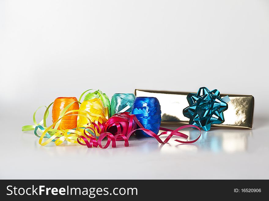 Set of colourful ribbons and a christmas gift on the white background. Set of colourful ribbons and a christmas gift on the white background