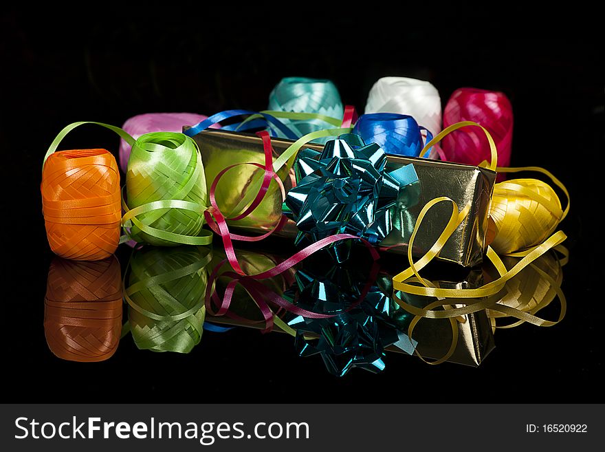 Set of colourful ribbons and a christmas  gift on the black background