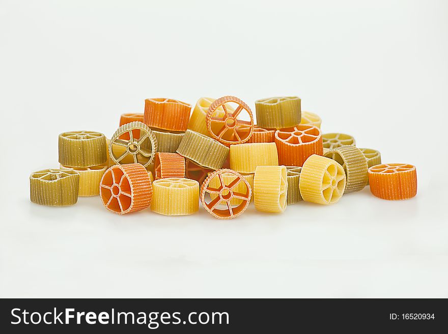 Bunch of round pasta in three colors: yellow, green, orange