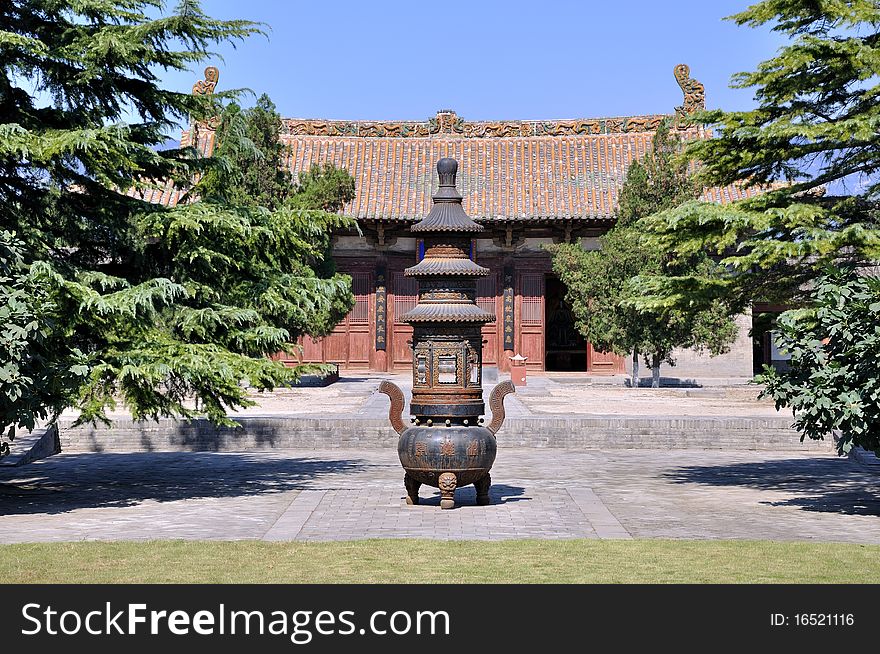 Courtyard and an old censer in Chinese temple, surround with traditional architecture and trees. Courtyard and an old censer in Chinese temple, surround with traditional architecture and trees.