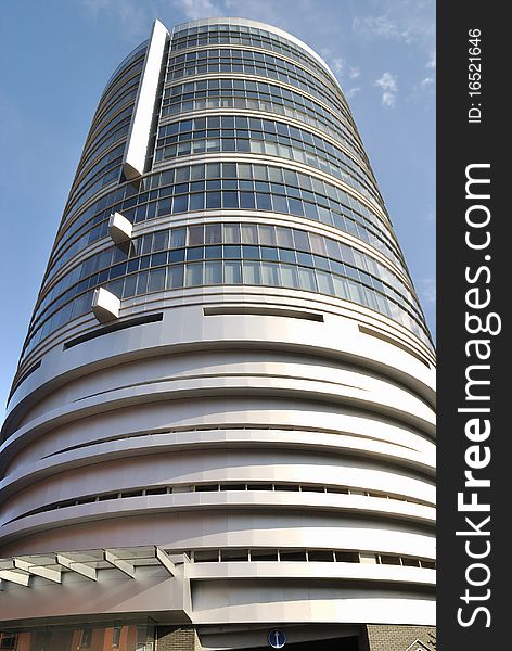 The building looking like tower is against blue sky. The view from bellow. The building looking like tower is against blue sky. The view from bellow.