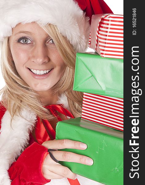 A female dressed like santa is peeking around some presents. A female dressed like santa is peeking around some presents.