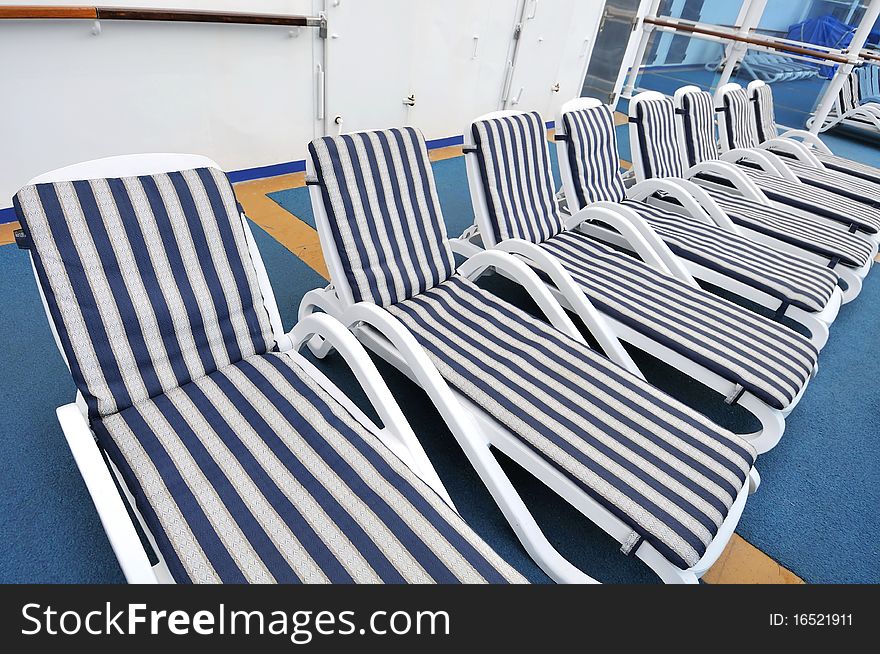 Row of blue beach chairs on cruise ship deck. Row of blue beach chairs on cruise ship deck