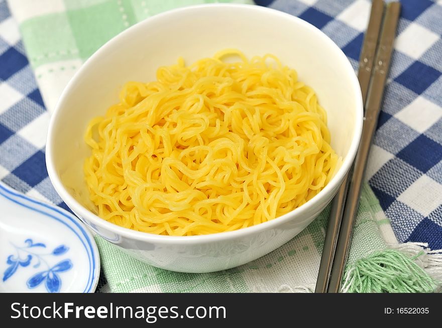 Generic yellow noodles with eating utensils.