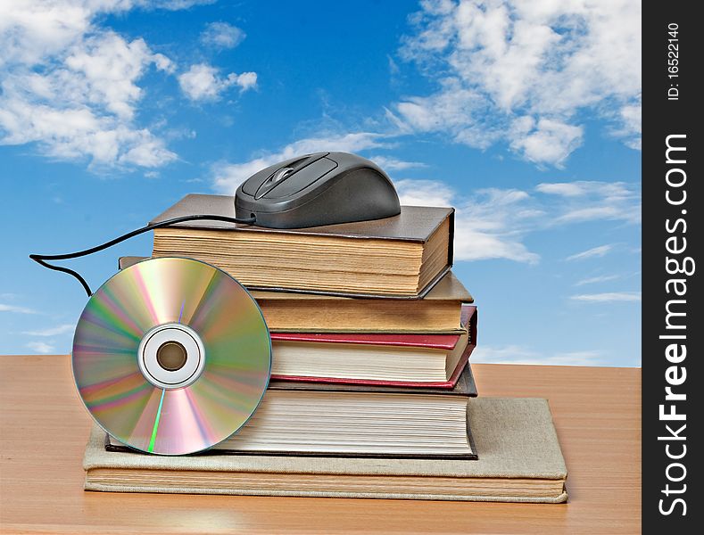 Books, dvd, and mouse on desk