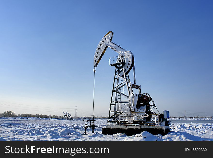 Cold winter, oil producing equipment is covered with snow. Cold winter, oil producing equipment is covered with snow