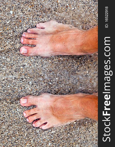 Feet of man at the beach with water