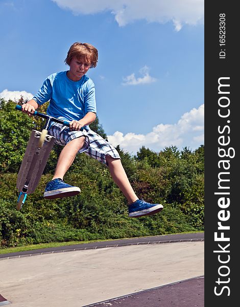 Young boy going airborne with his scooter
