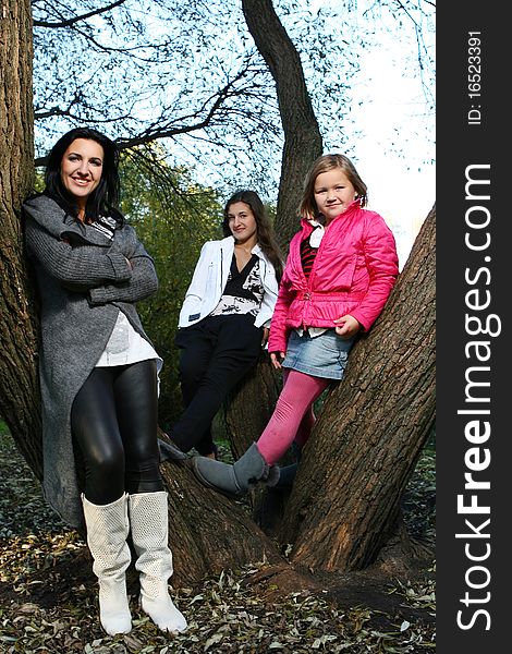 Young family taking healthy stroll through autumn park and have fun