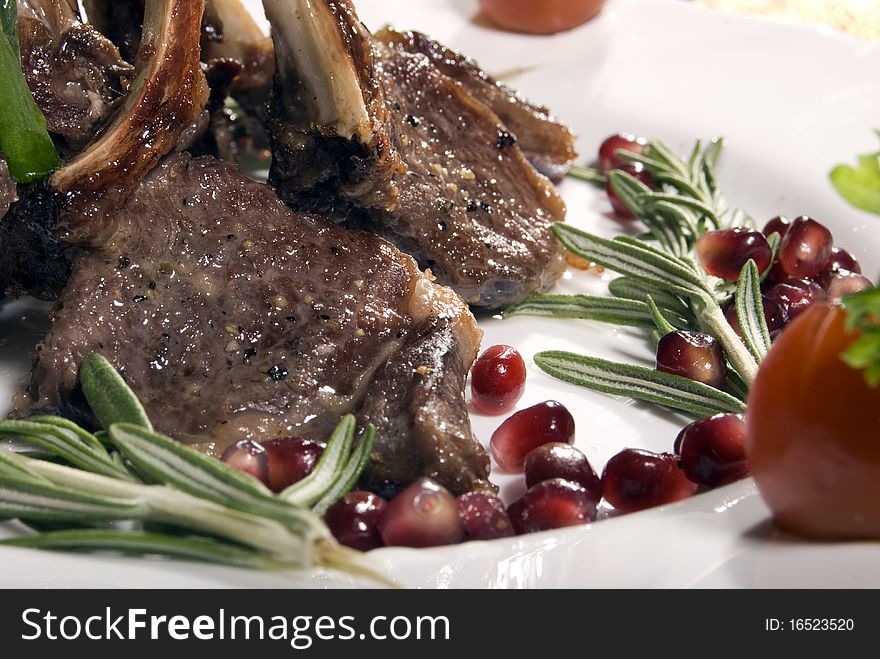 Fried rib served with pomegranate and salad. Fried rib served with pomegranate and salad