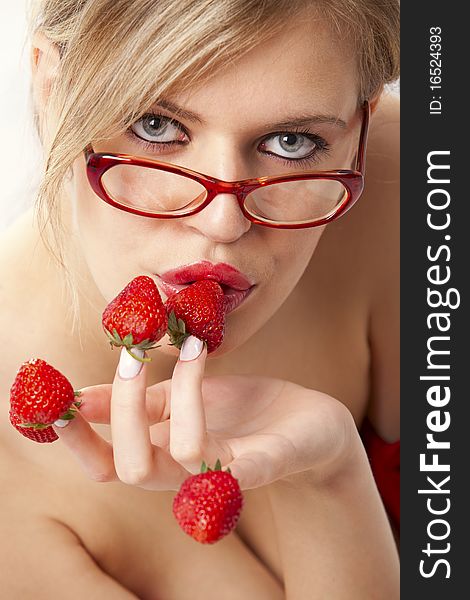 young woman with red strawberries picked on fingertips isolated on white background