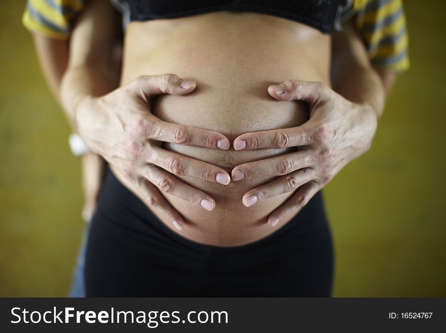 Father holding pregnant belly of a woman