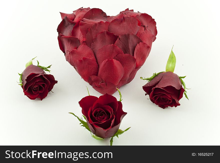 Large heart made from rose petals, surrounded by three red roses. Large heart made from rose petals, surrounded by three red roses