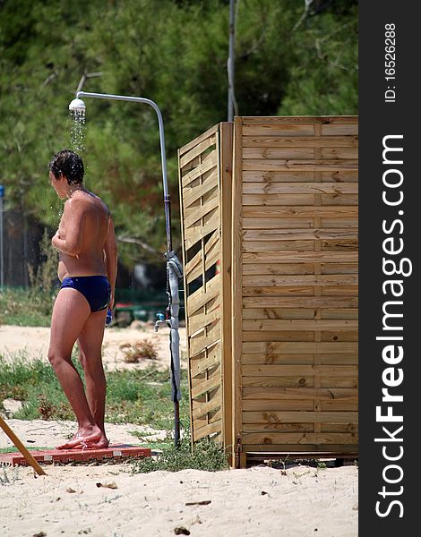 Man on the beach under the shower. Man on the beach under the shower