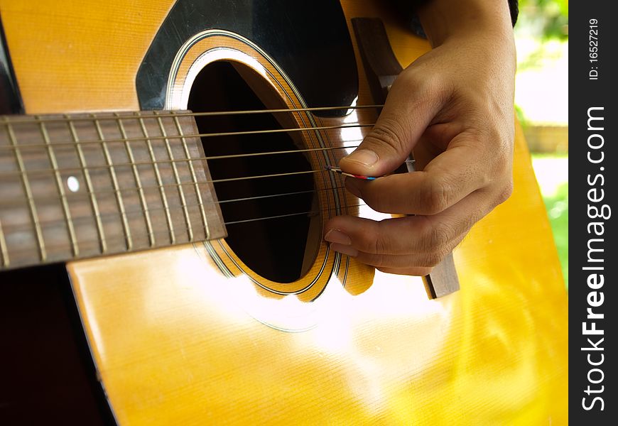 Man playing folk guitar with left hand