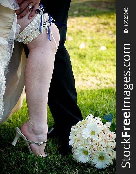 Groom’s hand on bride's leg with blue garter