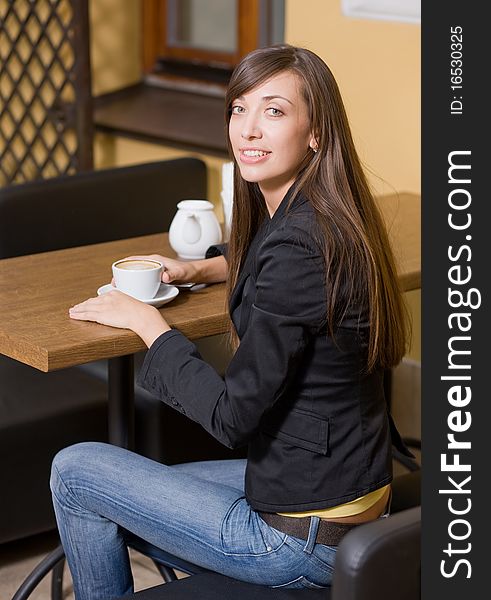 Beautiful girl with cup of coffee in cafe