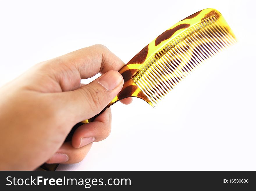 Hand holding green comb isolated on white background