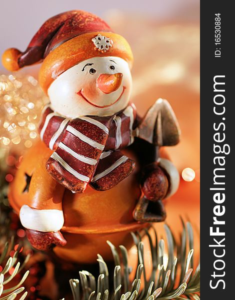 Snow-man figure in warm, orange colours with decoration material. Snow-man figure in warm, orange colours with decoration material
