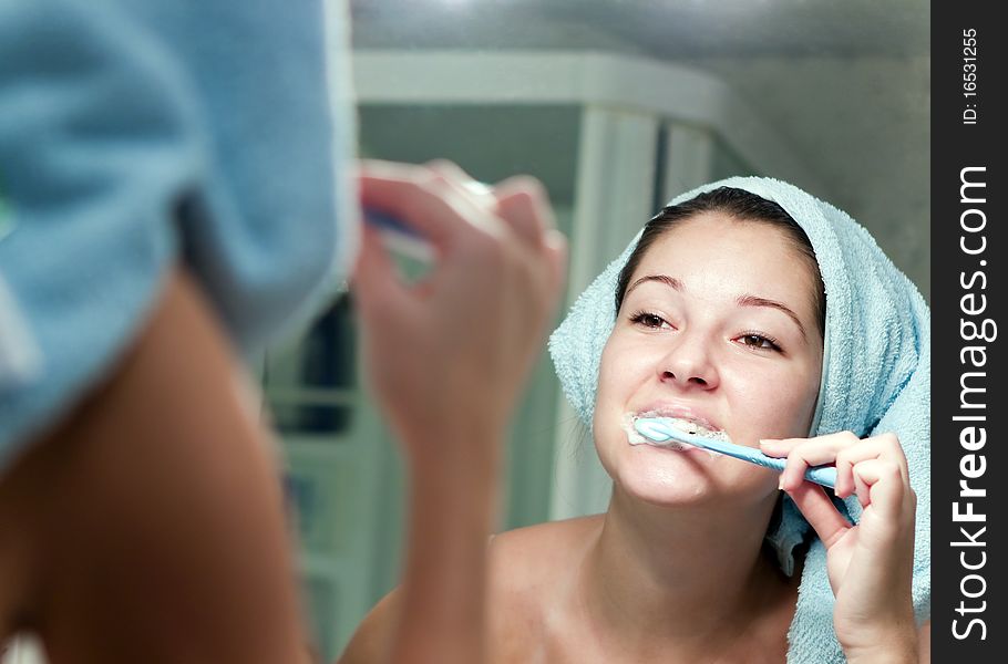 Girl carefully brushing his teeth in the mirror. Girl carefully brushing his teeth in the mirror
