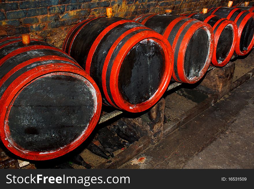 Wine barrels stacked in the old cellar of the winery