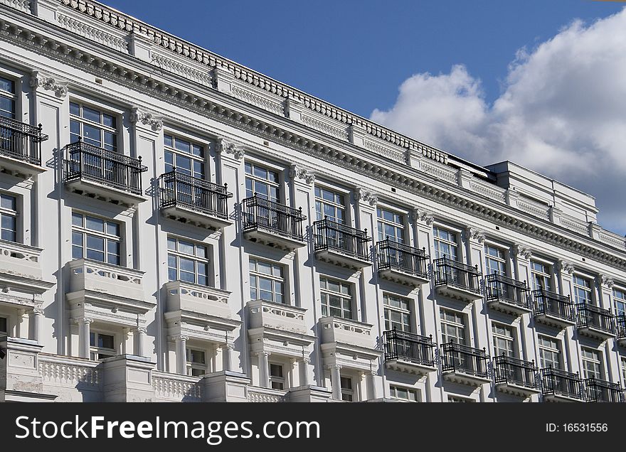 Long white building and blue sky with white clouds