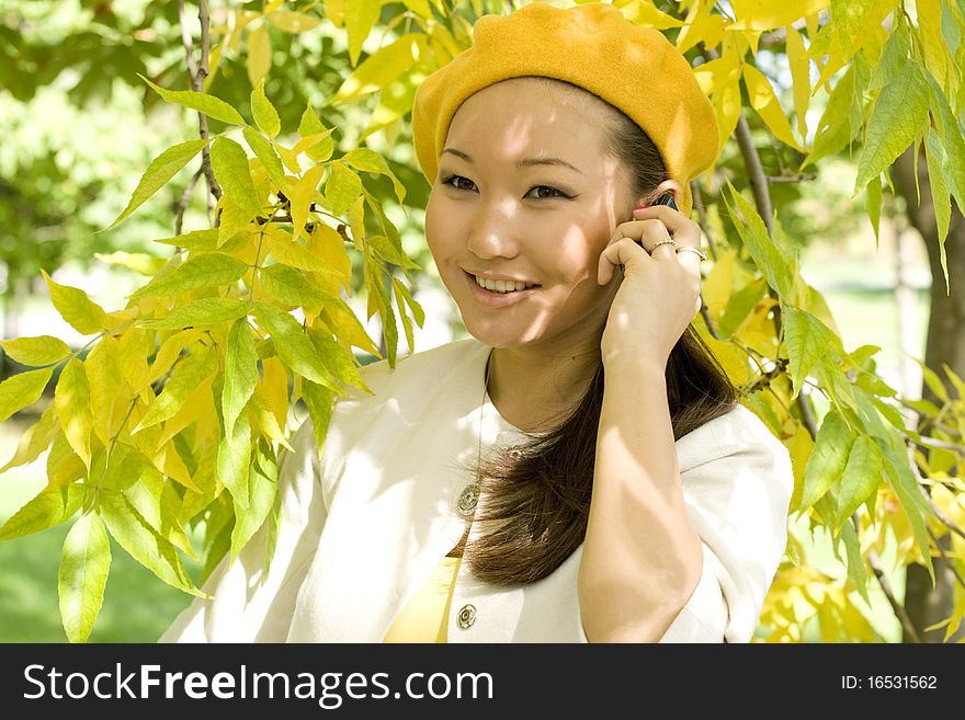 Girl talking by phone in autumn park