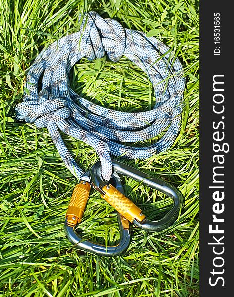 Climbing equipment - carabiners and rope on the grass