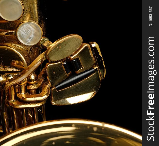 Close-up of a well used tenor saxophone on a black background