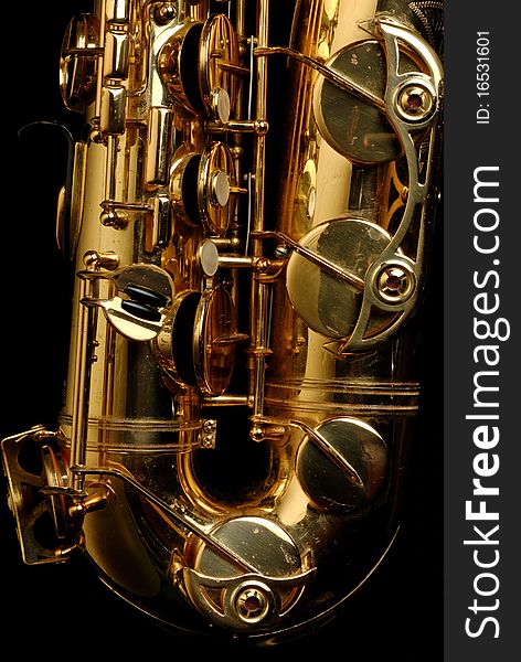 Close-up of a well used tenor saxophone on a black background
